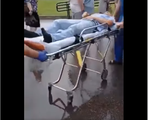 Rubrique lue - Site Vax. Les gens font la queue pour se faire vacciner, tandis qu'une personne injectée est transportée en ambulance !